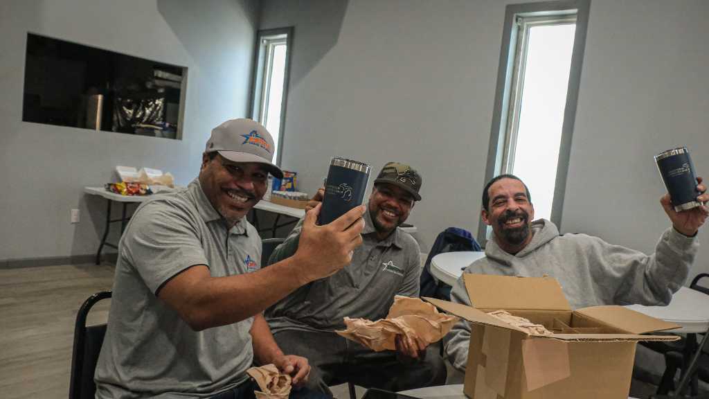 Detroit Home Builders team smiling with mugs